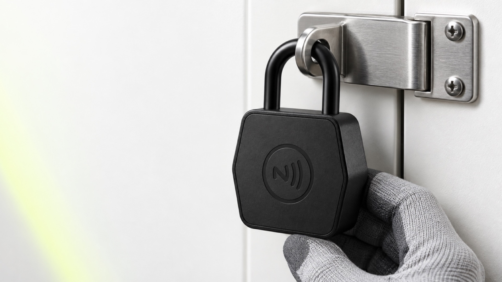 A gloved hand fitting the padlock through a hasp on a unit door